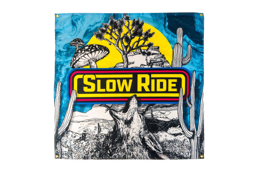 Desert Landscape Banner - Slow Ride Bold and colorful Slow Ride banner featuring a striking desert landscape with a howling coyote, cacti, mushrooms, and a vibrant yellow sun. Perfect for fans of vintage Volkswagen culture, including the iconic Volkswagen bus, Volkswagen bug, and Baja bug, this banner captures the adventurous spirit of Off-Roading and Off-Road Racing. Ideal for showcasing your love for slow ride t-shirts and the open road.