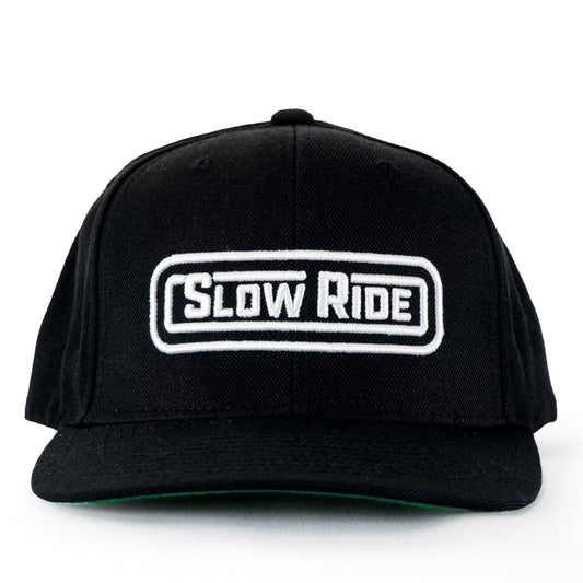 Radio Hat (Black) - Slow Ride- Classic black snapback hat featuring the 'Slow Ride' logo embroidered in white on the front. Perfect for fans of Off-Roading, Off-Road Racing, and vintage Volkswagen culture, including the iconic Volkswagen bus, Volkswagen bug, and Baja bug. This hat is ideal for those who embrace the Garage and Racing lifestyle and live by mottos like 'Enjoy Getting There,' 'Wheelin and Spilling,' and 'Restore and Destroy.' A must-have accessory for blue-collar workwear enthusiasts and racing